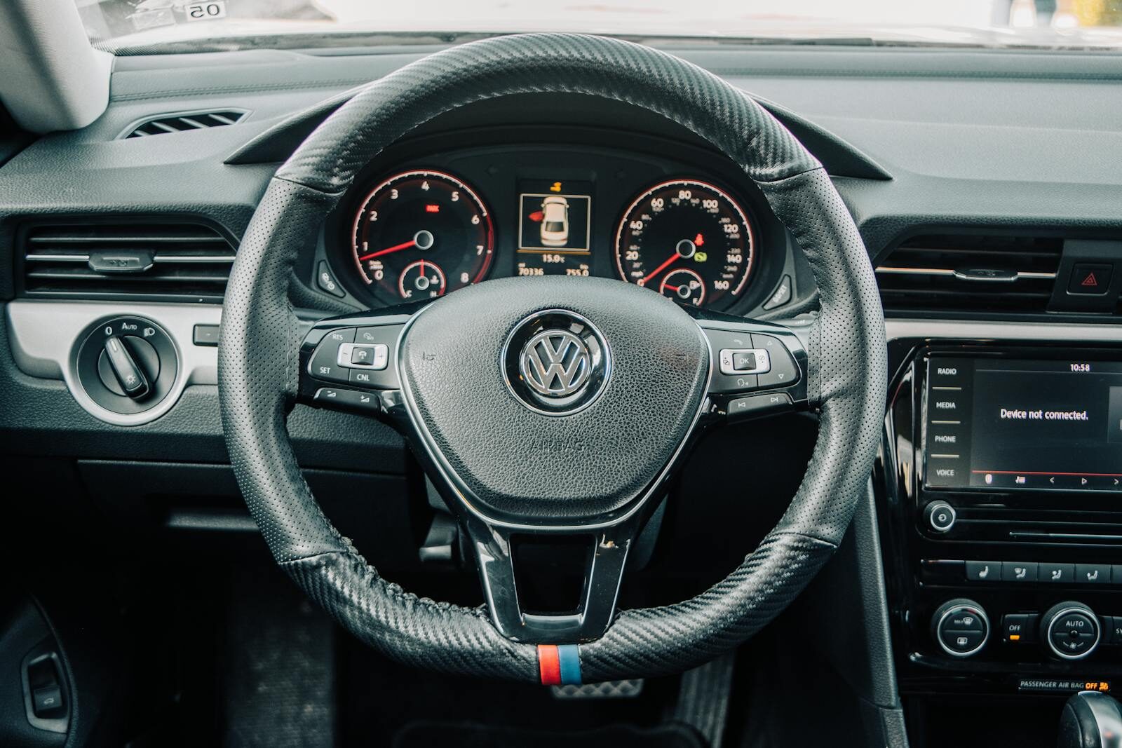 Detailed view of Volkswagen car interior showing steering wheel and dashboard.