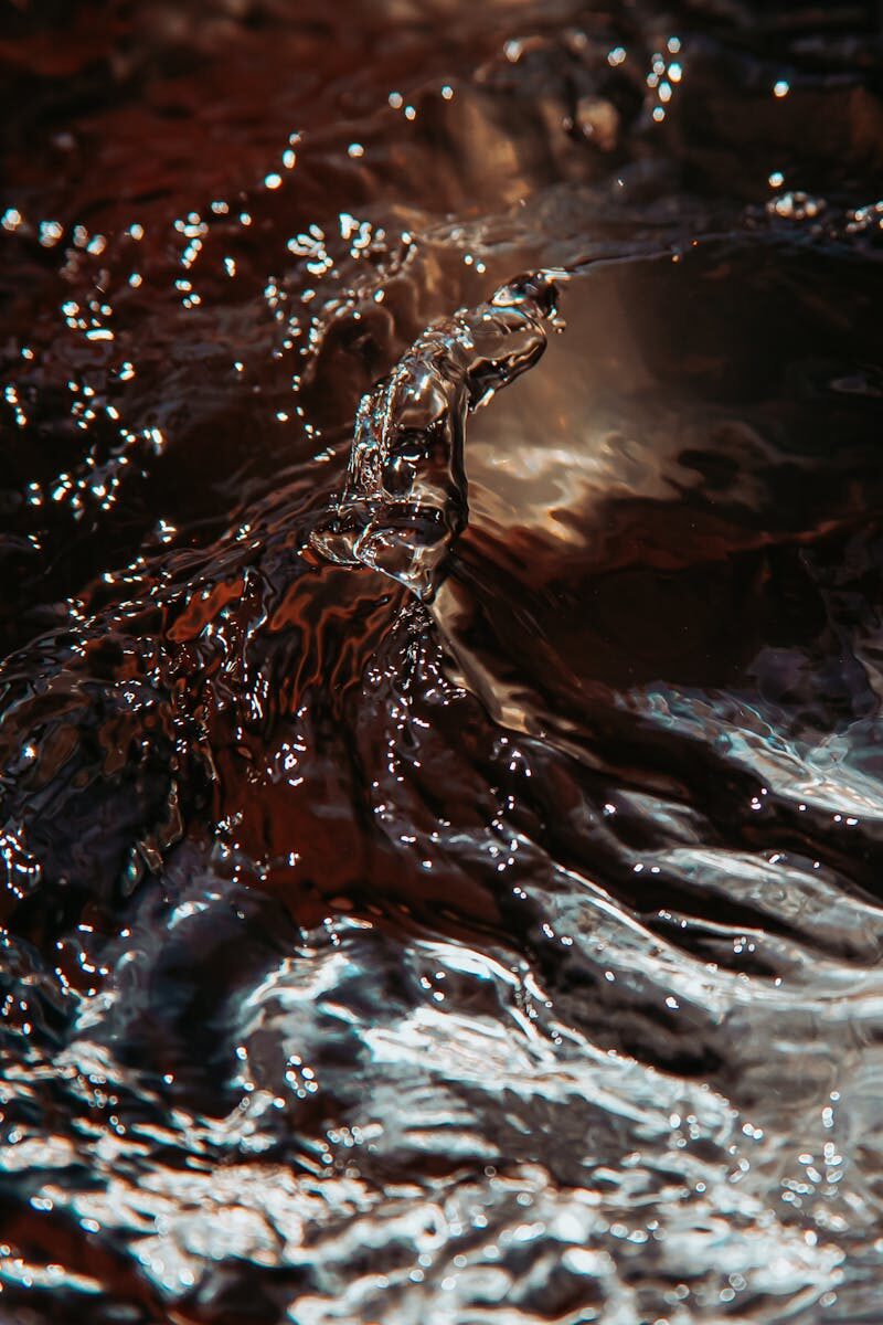Captivating close-up of water splashing with dynamic motion, showcasing vibrant reflections and fluid textures.