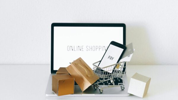 Display of online shopping theme with mini cart and payment devices on laptop.