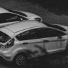 A monochrome image showcasing parked cars in an urban environment.