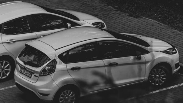 A monochrome image showcasing parked cars in an urban environment.