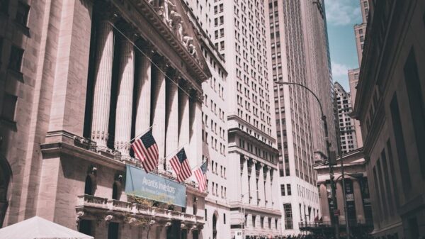 View of New York Stock Exchange on a busy day with American flags and skyscrapers.