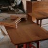 Wooden furniture pieces on a workshop table, demonstrating craftsmanship.