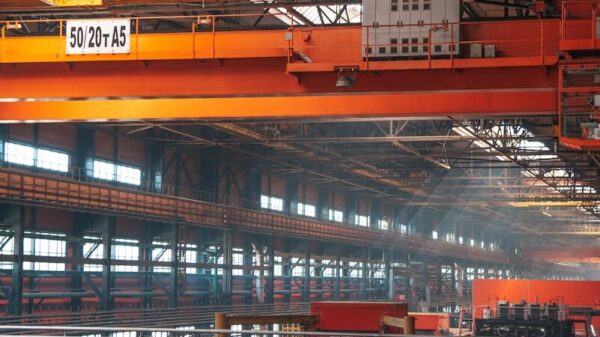 Spacious factory interior featuring large overhead cranes and metal walkways.