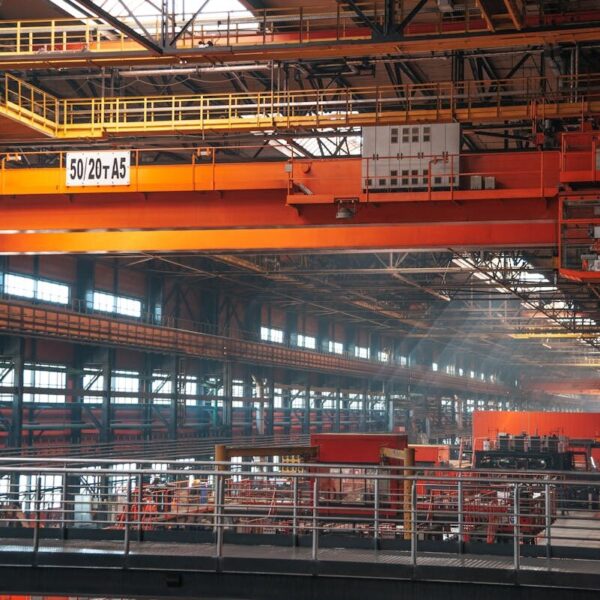 Spacious factory interior featuring large overhead cranes and metal walkways.