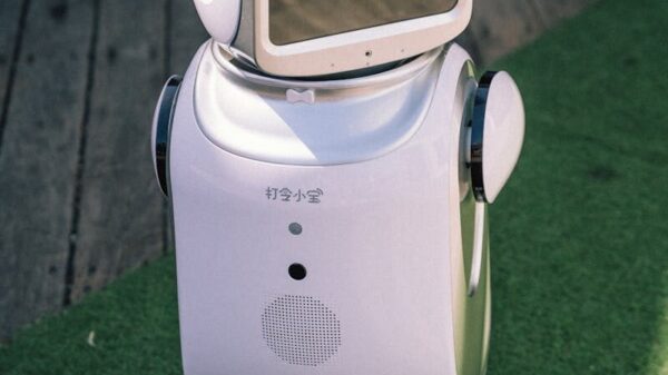 A modern robot stands on grass and wooden flooring, showcasing cutting-edge technology.