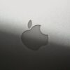 Close-up of a sleek silver Apple logo on a metallic surface, showcasing branding elegance.