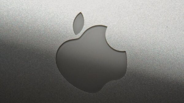Close-up of a sleek silver Apple logo on a metallic surface, showcasing branding elegance.