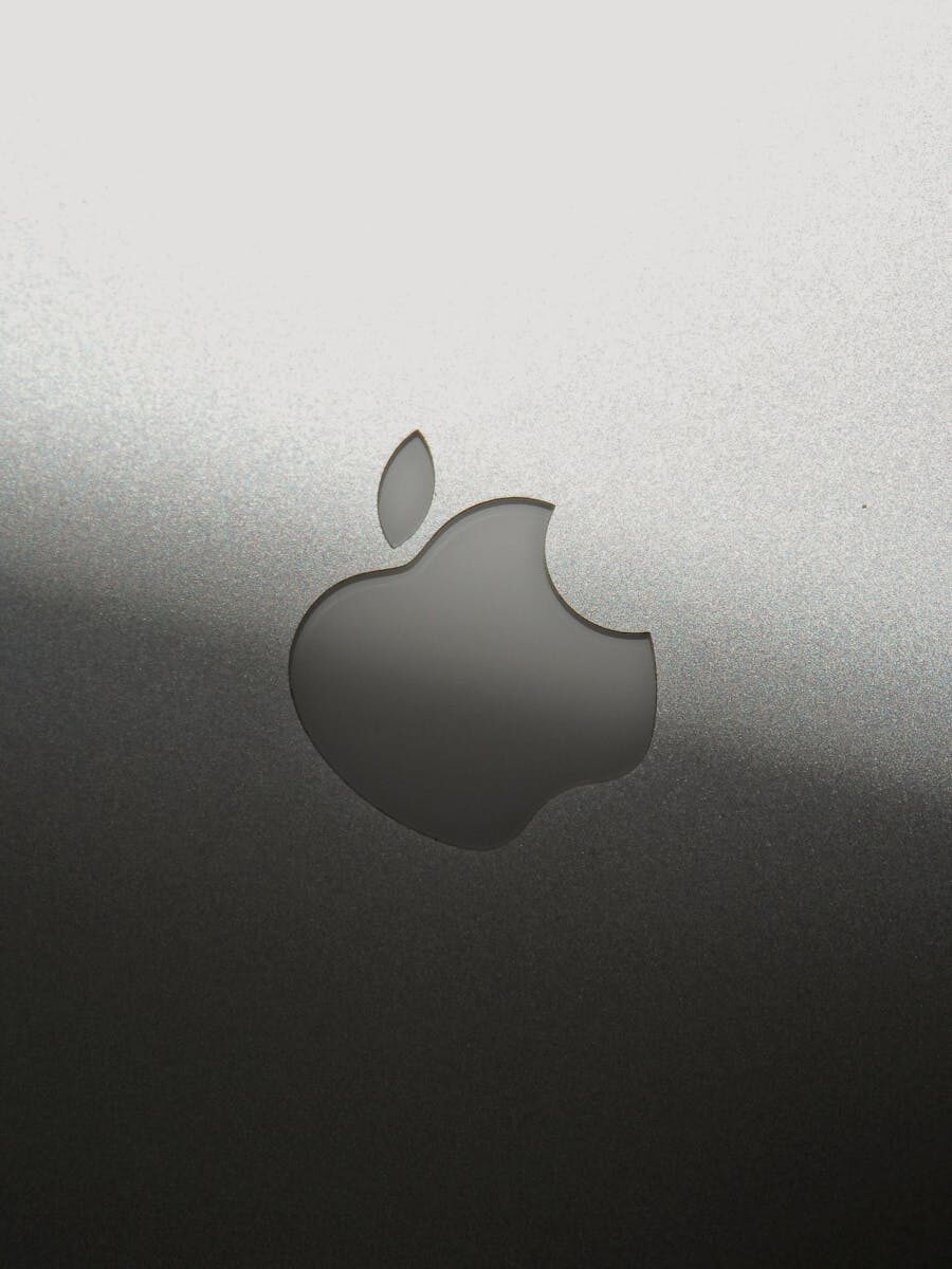 Close-up of a sleek silver Apple logo on a metallic surface, showcasing branding elegance.
