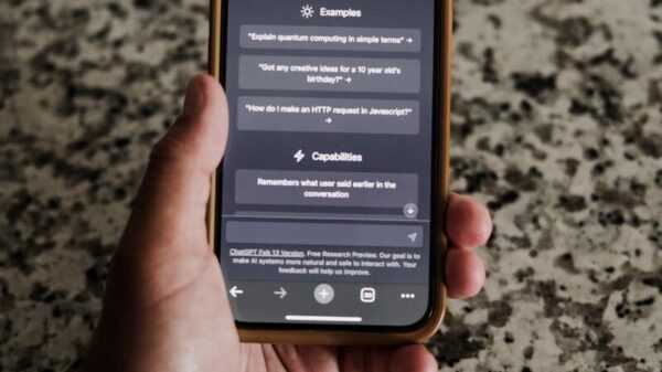 A close-up of a hand holding a smartphone with ChatGPT interface on display.