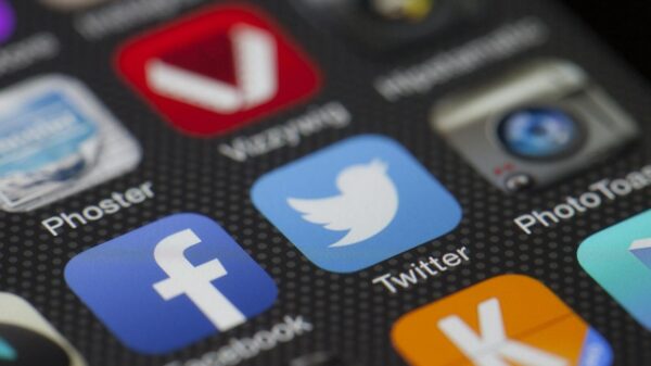A detailed close-up of social media icons on a smartphone screen, including Facebook and Twitter.