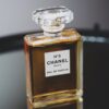 Luxurious Chanel No. 5 perfume bottle with chic design on a gray backdrop.
