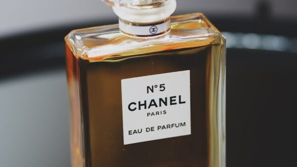 Luxurious Chanel No. 5 perfume bottle with chic design on a gray backdrop.
