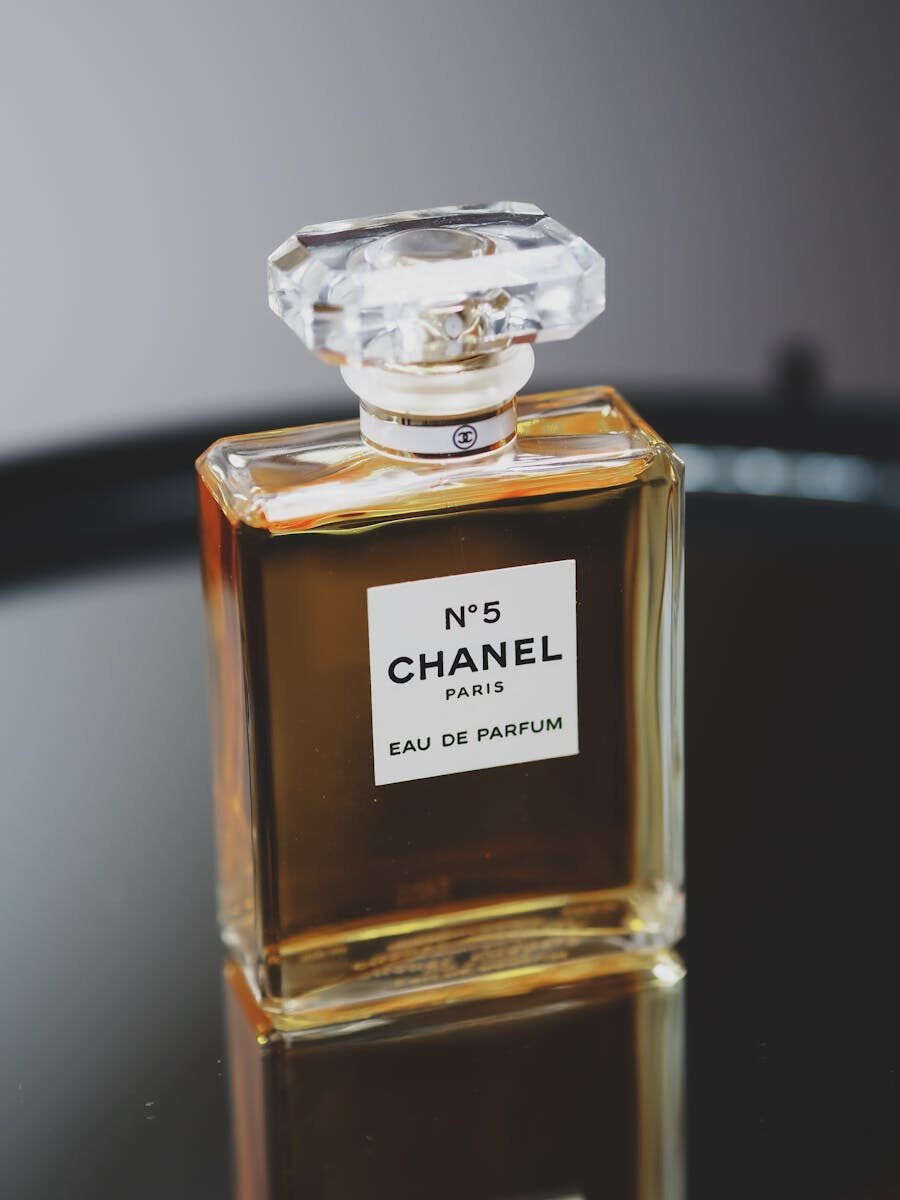 Luxurious Chanel No. 5 perfume bottle with chic design on a gray backdrop.