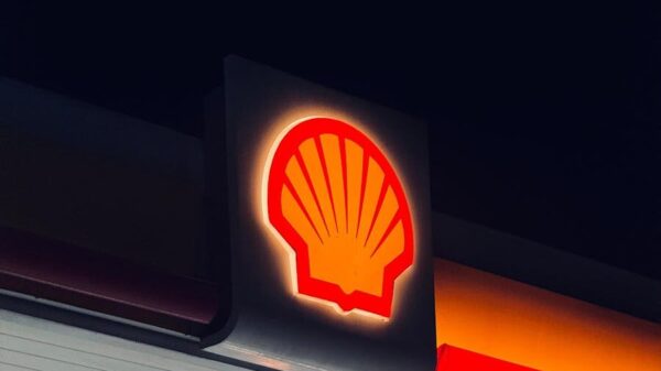 Illuminated Shell gas station sign captured at night in Bengaluru, India.