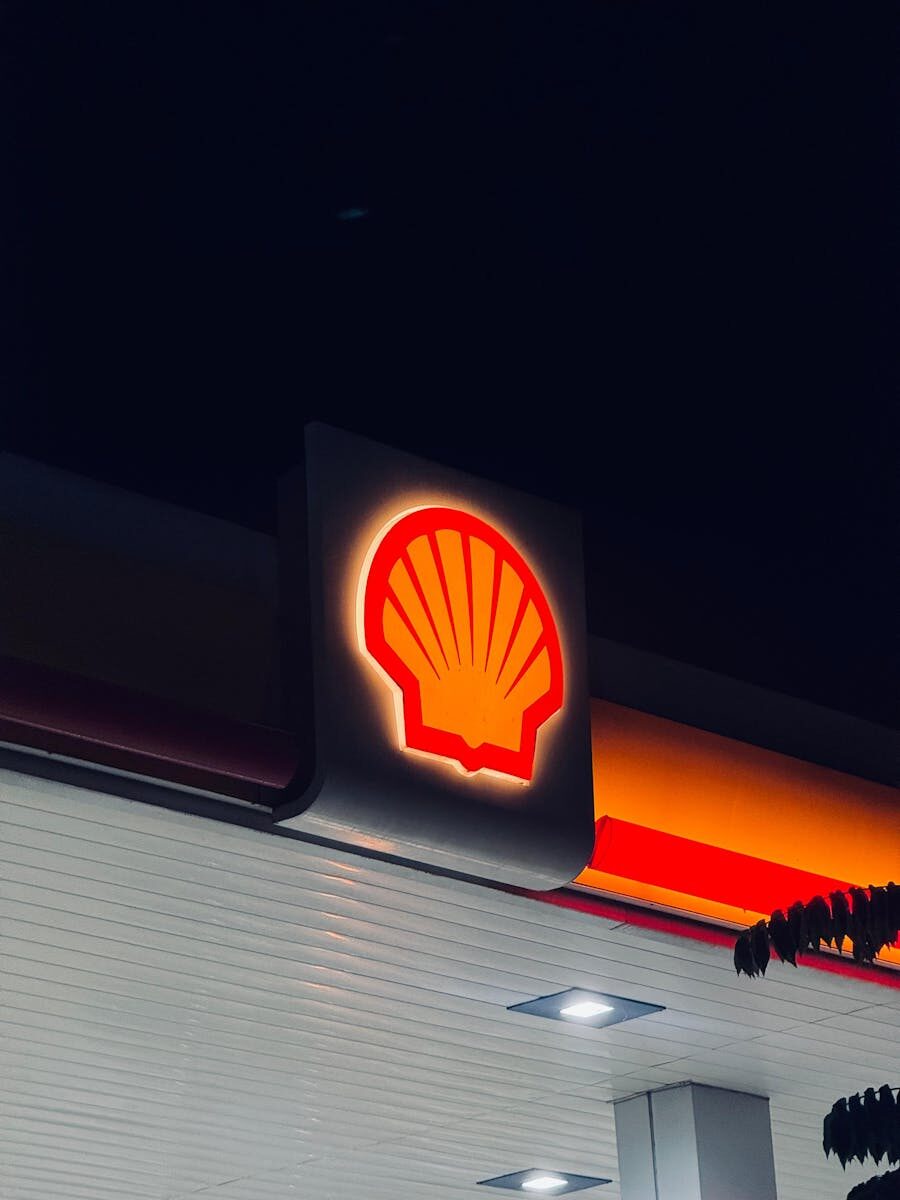Illuminated Shell gas station sign captured at night in Bengaluru, India.