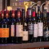A variety of wine bottles elegantly displayed at a bar, including red, white, and sparkling wines.
