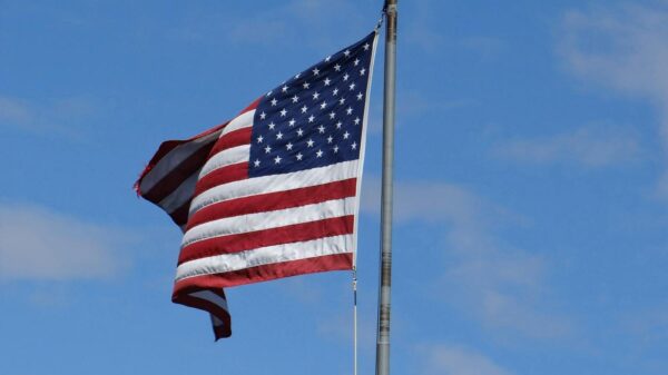 US flag flying in clear blue sky at Mackinac Island, MI. Symbol of American patriotism.