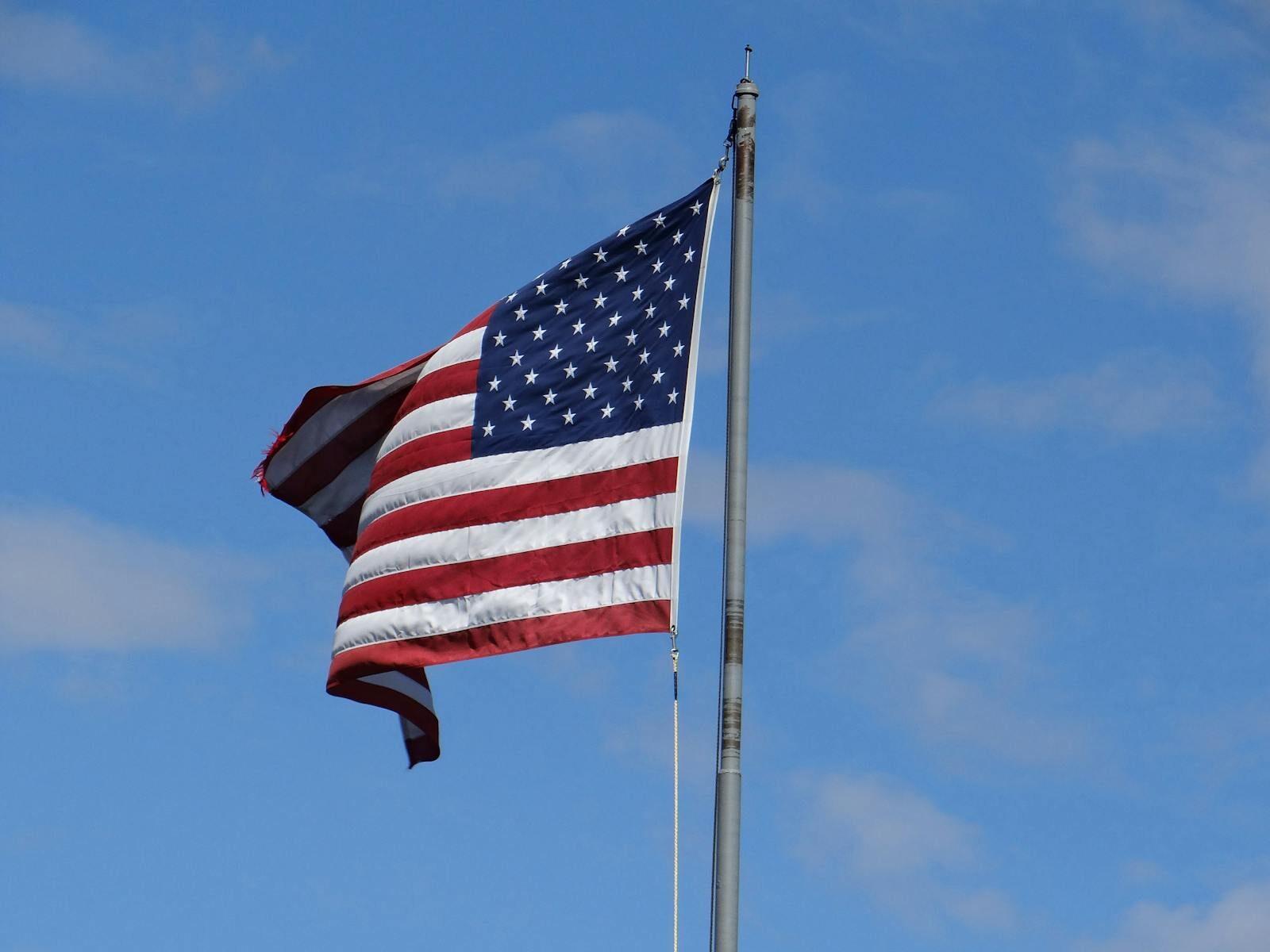 US flag flying in clear blue sky at Mackinac Island, MI. Symbol of American patriotism.