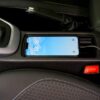 A smartphone charging in a car's central console, showcasing modern automotive technology.