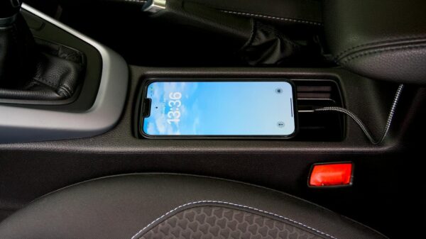 A smartphone charging in a car's central console, showcasing modern automotive technology.