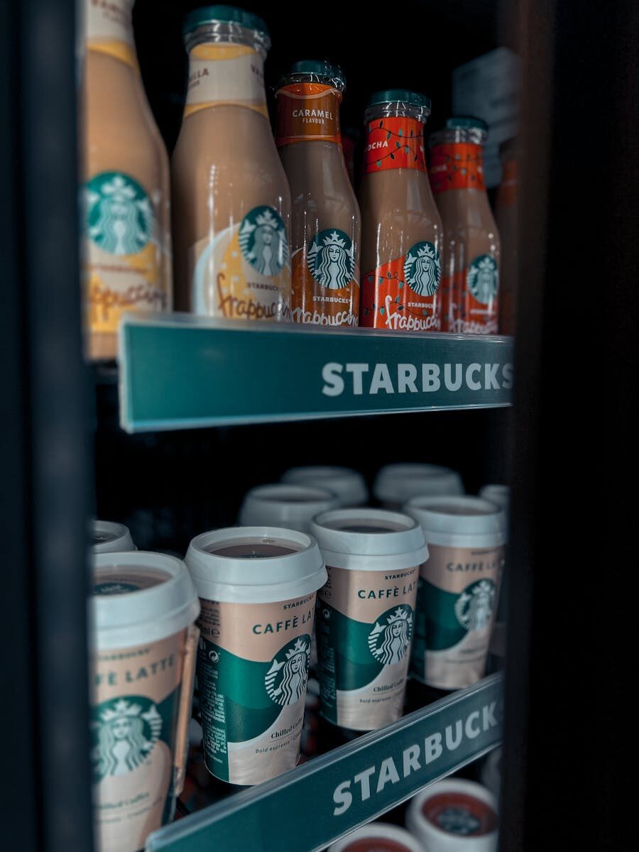 Assorted Starbucks drinks displayed in a cooler, featuring coffee and frappuccino bottles.