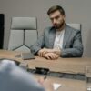 Two businessmen in a formal meeting room, discussing important matters.