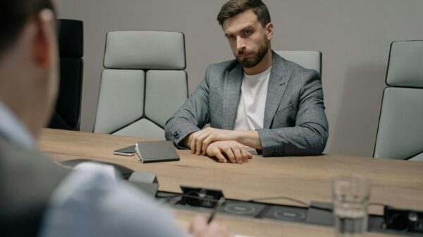 Two businessmen in a formal meeting room, discussing important matters.