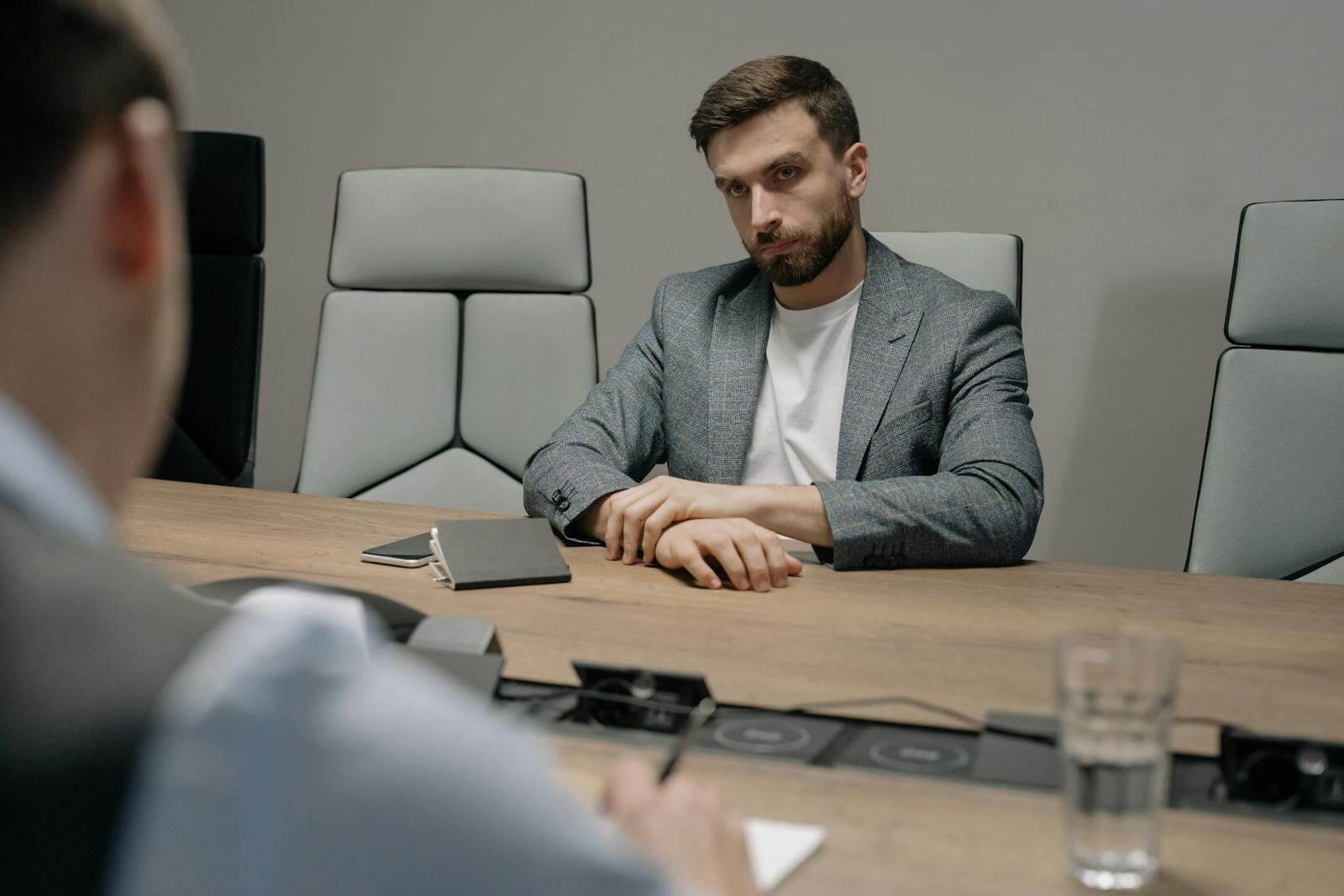 Two businessmen in a formal meeting room, discussing important matters.