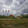Belgrade sign with Serbian flags under dramatic overcast sky, capturing national pride.