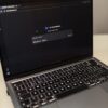 Close-up of a laptop showing an AI chat interface in a dimly lit room.