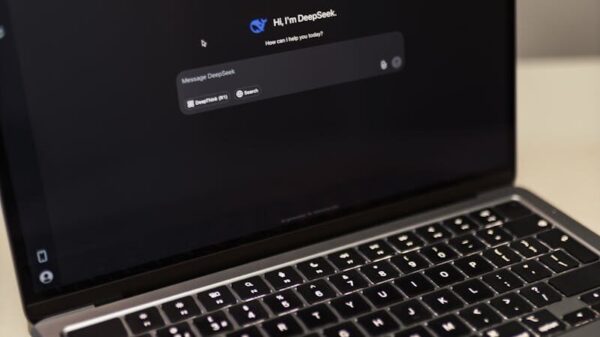 Close-up of a laptop showing an AI chat interface in a dimly lit room.