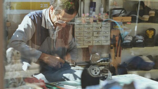 An experienced shoemaker working in a traditional workshop, surrounded by tools and materials.