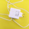 White USB charger with cable on a vibrant yellow surface, highlighting tech accessory design.