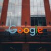 Colorful Google logo on modern building exterior in urban environment.