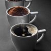 A journey of coffee from beans to a fresh brew in three cups, highlighting the stages of preparation.