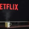 A steaming mug on a table in front of a TV displaying Netflix, creating a cozy indoor atmosphere.