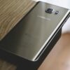 A sleek Samsung smartphone placed on a wooden surface, capturing modern elegance.