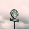 A Starbucks Coffee sign with a cloudy sky backdrop in Brazil, creating a moody ambiance.