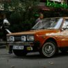 Classic orange car parked on a bustling Istanbul street with a nostalgic ambiance.