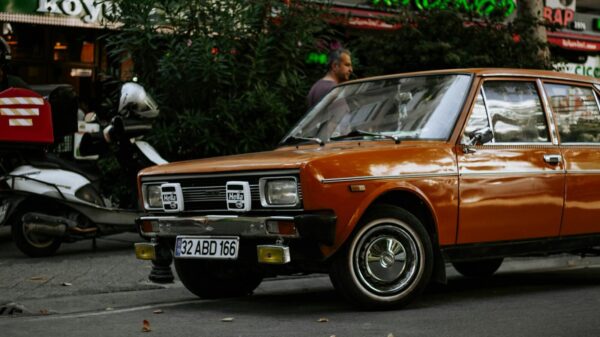 Classic orange car parked on a bustling Istanbul street with a nostalgic ambiance.