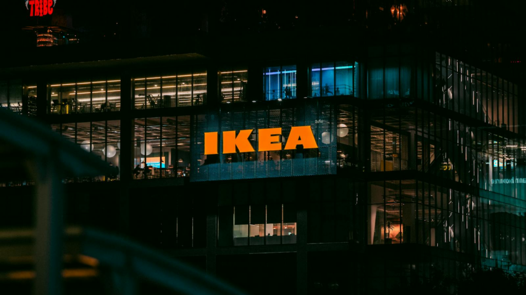 Illuminated view of an IKEA store in Bangkok at night, showcasing vibrant city lights.