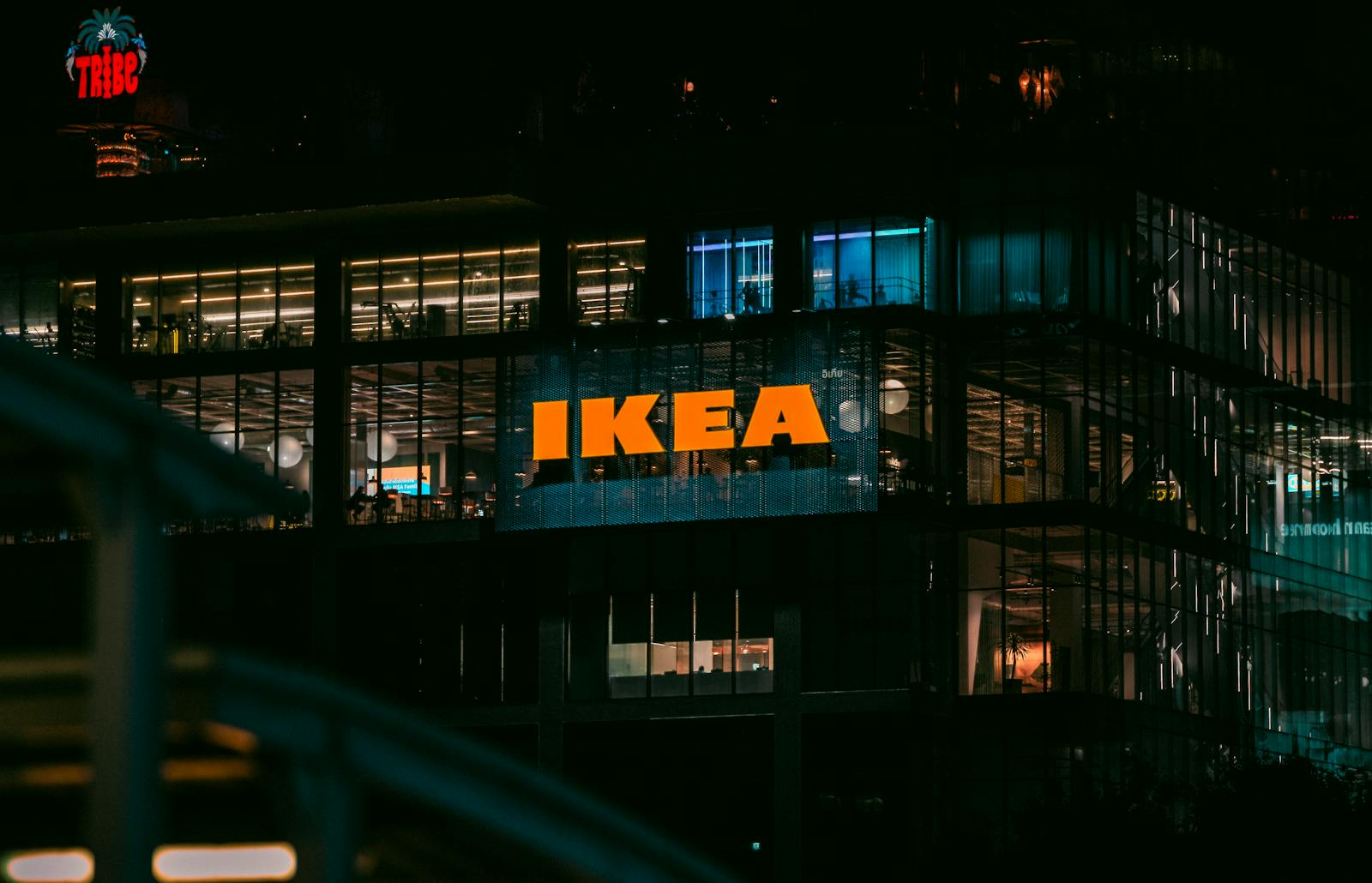 Illuminated view of an IKEA store in Bangkok at night, showcasing vibrant city lights.