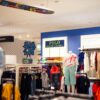 Vibrant clothing display at a modern retail store with mannequins featuring popular fashion brands.