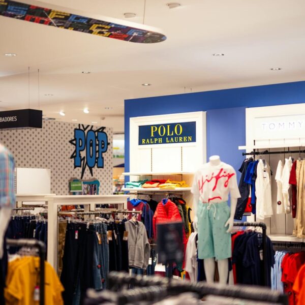Vibrant clothing display at a modern retail store with mannequins featuring popular fashion brands.