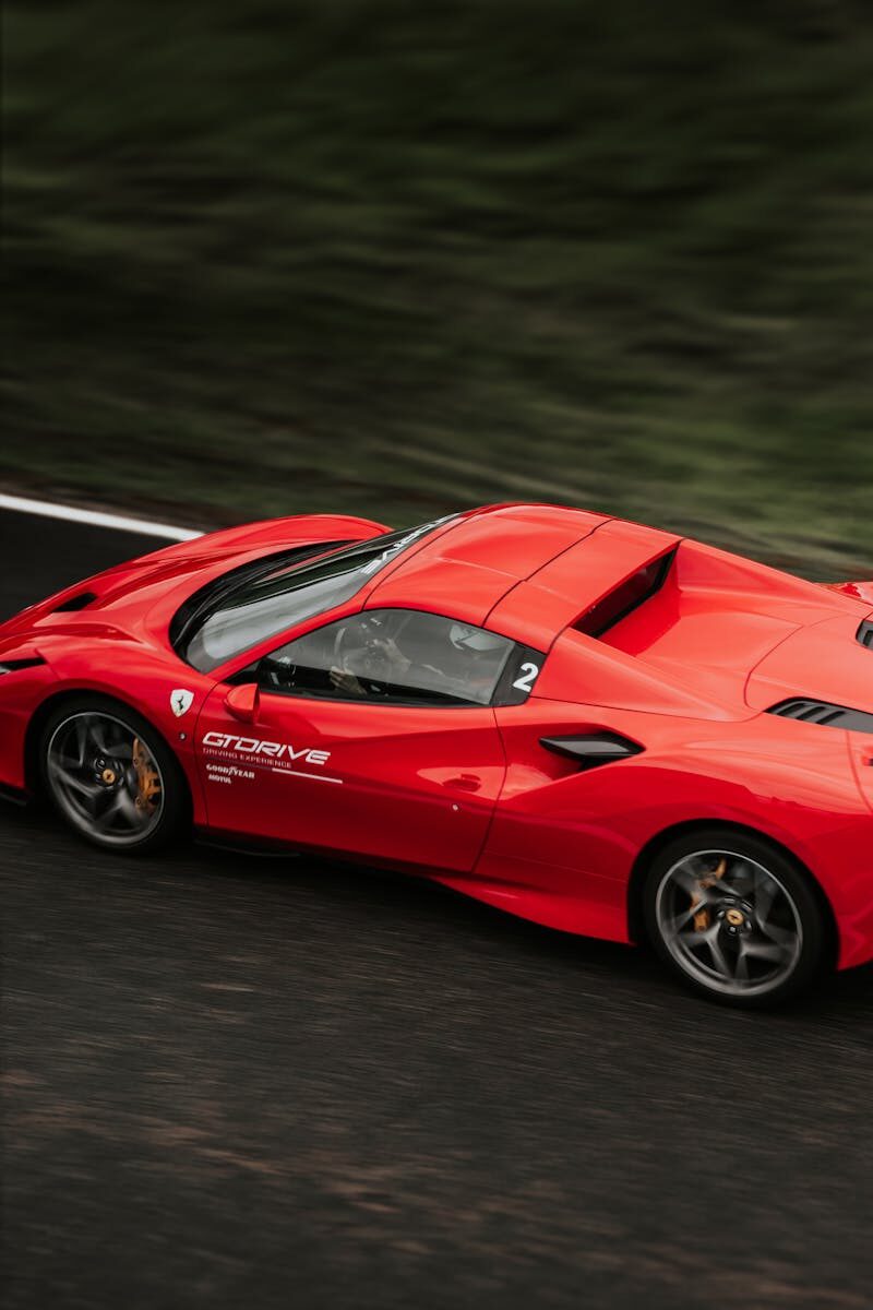 Dynamic shot of a red supercar speeding on a race track in Pau, France.