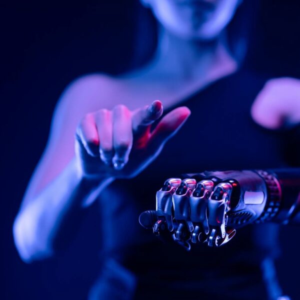 Close-up of a robotic hand with a woman pointing, showcasing advanced prosthetic technology.