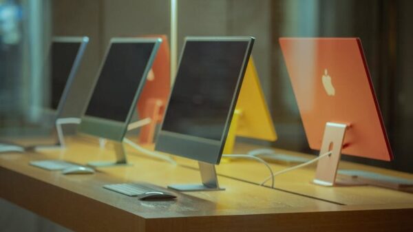 Vibrant desktop computers showcased on a wooden table in modern retail environment.