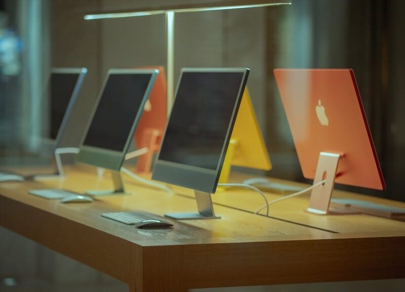 Vibrant desktop computers showcased on a wooden table in modern retail environment.