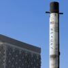 A SpaceX Falcon 9 rocket displayed outdoors against a clear blue sky in Dubai.